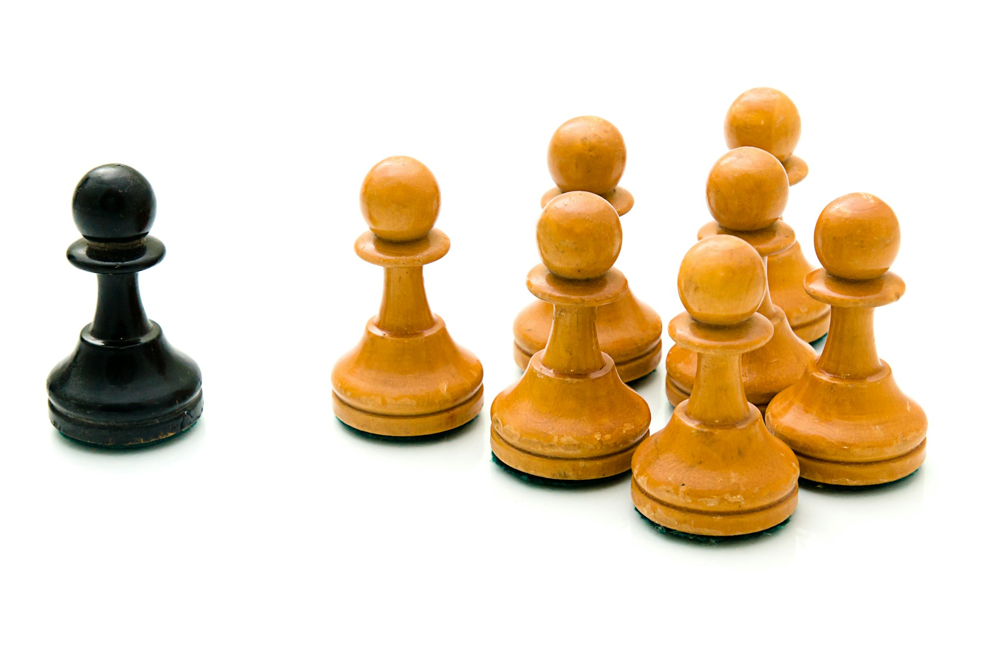 Closeup shot of a black pawn in front of a group of white pawns-strategy, teamwork concept